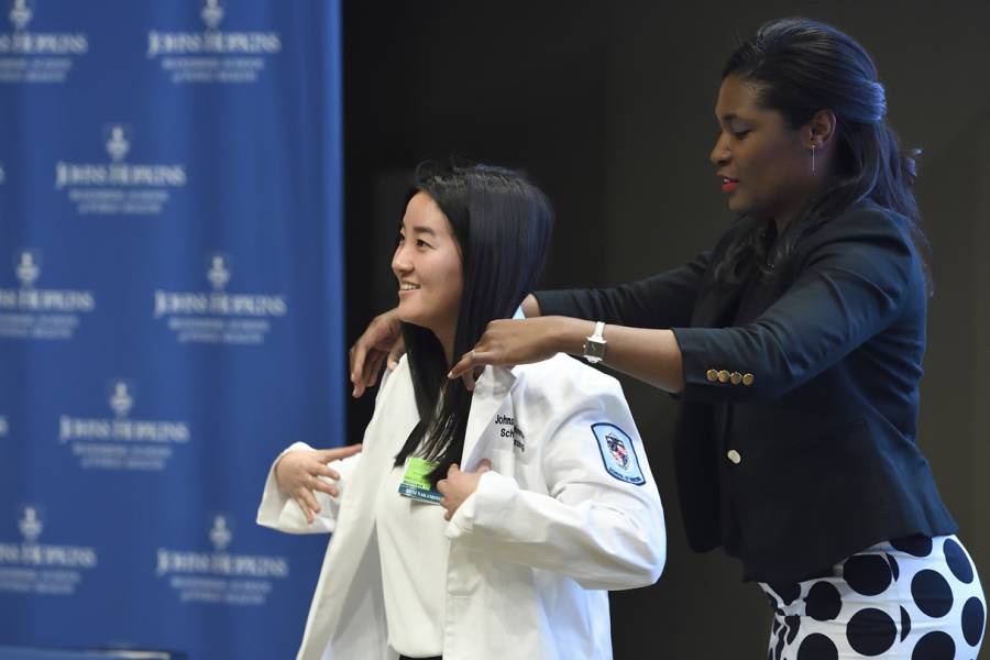 A student puts on a white coat