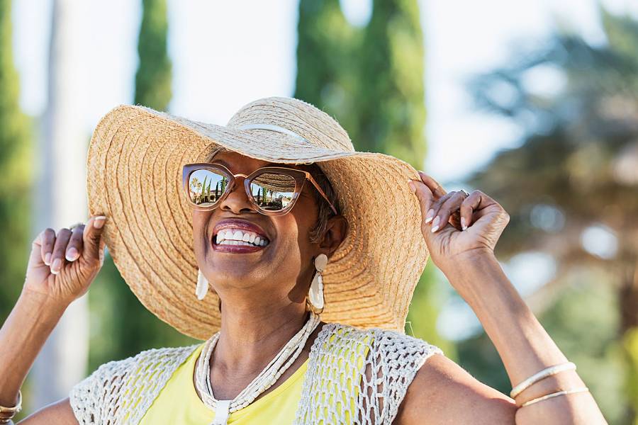 Smiling woman in big straw hat and sunglasses