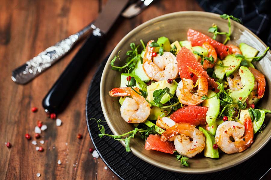 Shrimp, grapefruit, avocado, and greens in a salad bowl