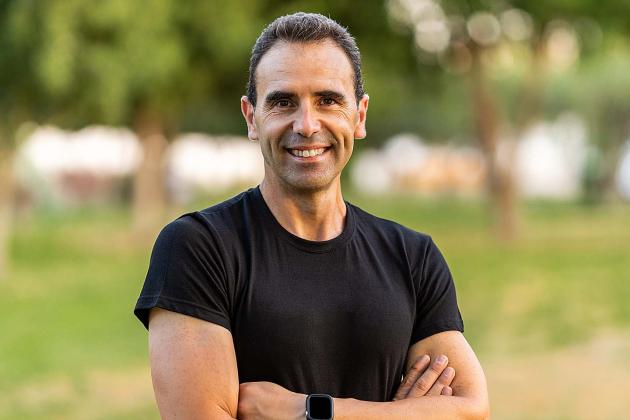Smiling, healthy-looking middle-aged man outdoors in a black T-shirt.
