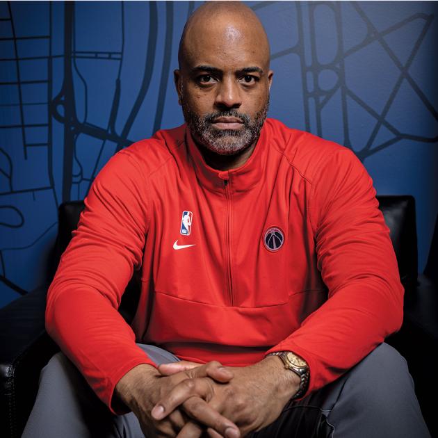 Wes Unseld Jr. in a red half-zip sweatshirt against a blue background