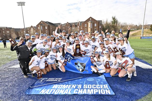 Johns Hopkins women's soccer team poses for a team photo with a trophy after winning the 2022 NCAA Division III championship