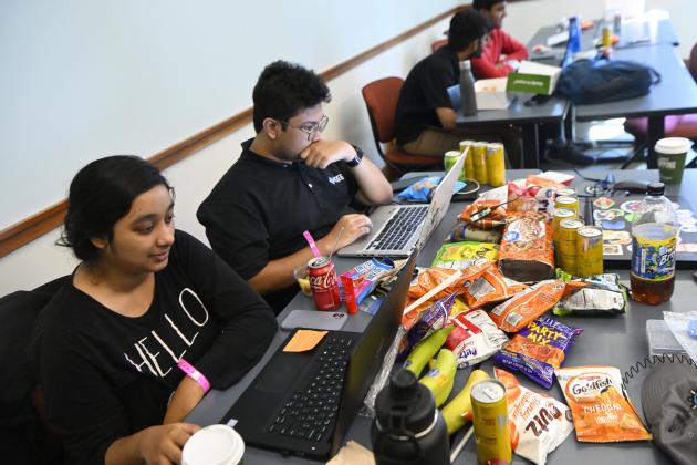 HopHacks students with laptops and a tableful of snacks