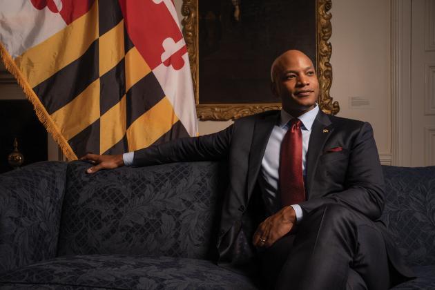 Governor Wes Moore sits in front of a Maryland flag