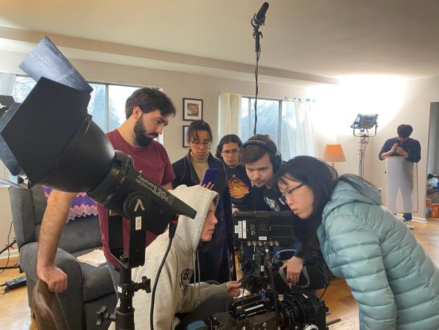 A Studio North crew crowded around the camera's monitor