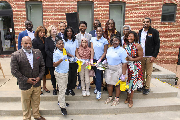 Community leaders and Henderson-Hopkins students and staff in a group photo with a ceremonial shovel
