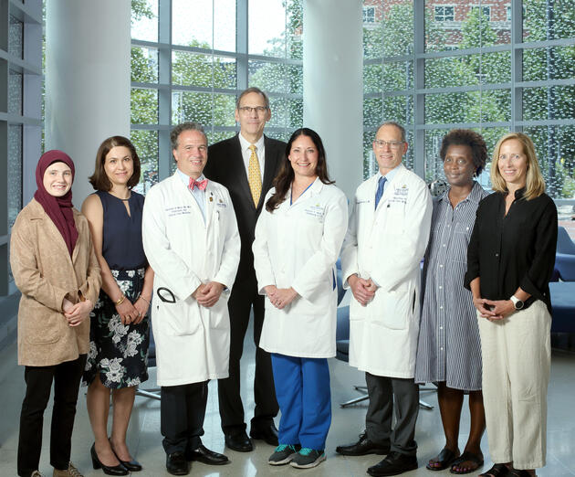 A team of eight people pose for a photo