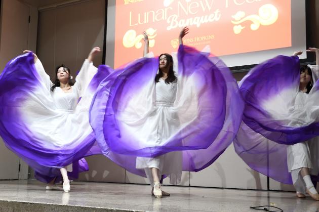 A group of dancers throw their skirts up.