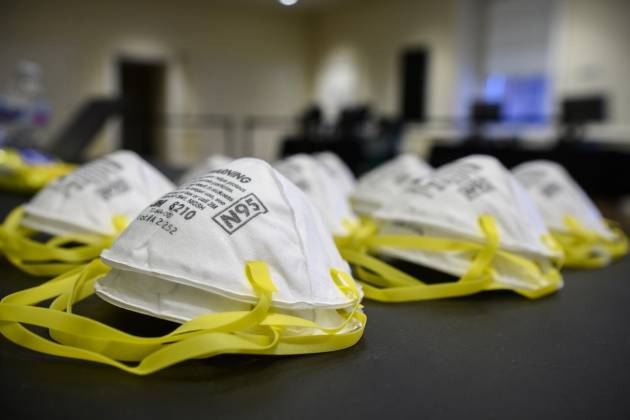 White N95 masks with yellow straps sit on a table in the Clipper Room in Shriver Hall on the Homewood campus.