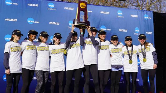 Johns Hopkins women's cross country team hoists NCAA championship trophy.