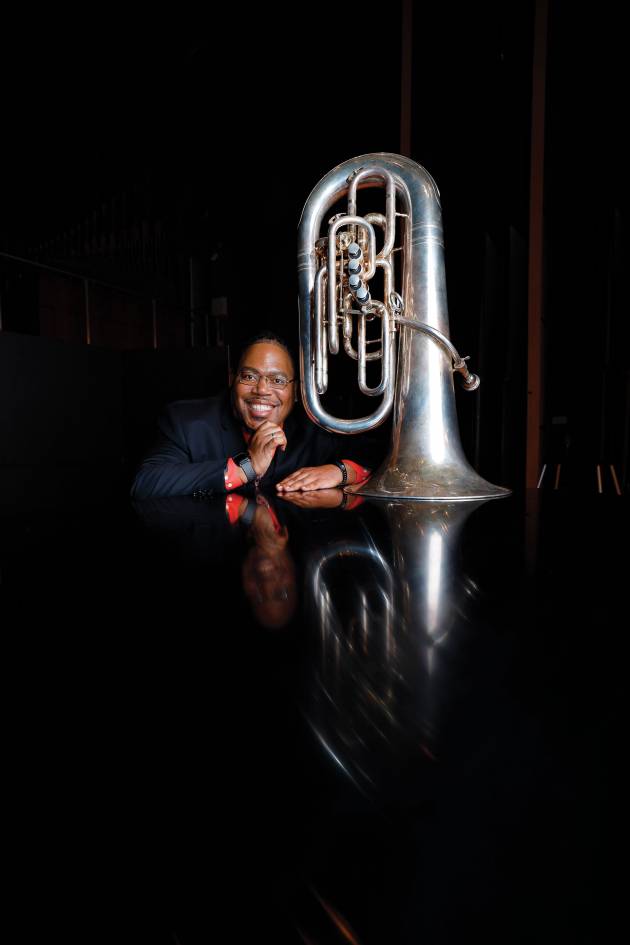 Richard A. White sits next to his tuba