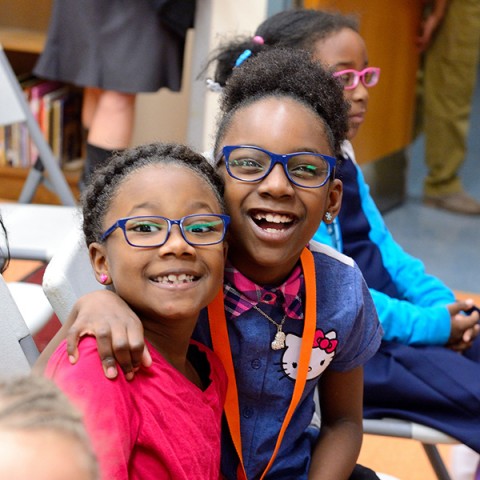 Two little girls smile in brand new glasses