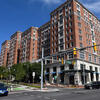 A multistory brick building is seen at a city intersection